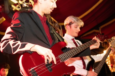 Des enfants colorient des dessins autour d'une table ronde, entourés d'adultes dans un espace intérieur animé.