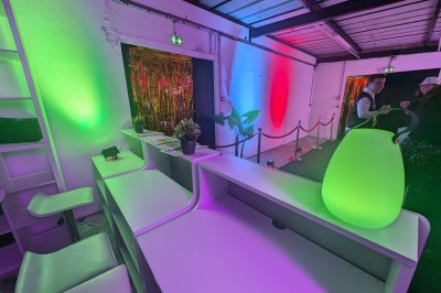 Miniature Location salle Seclin (Nord) - Luminaria #59 Décor festif avec ballons noirs, dorés, argentés et blancs, fond scintillant et deux tabourets blancs devant.