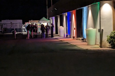 Miniature Location salle Seclin (Nord) - Luminaria #8 Décor festif avec ballons noirs, dorés, argentés et blancs, fond scintillant et deux tabourets blancs devant.