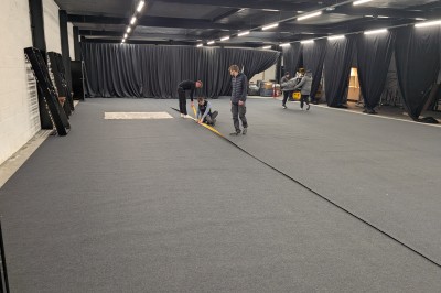 Miniature Location salle Seclin (Nord) - Luminaria #47 Décor festif avec ballons noirs, dorés, argentés et blancs, fond scintillant et deux tabourets blancs devant.