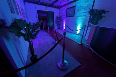 Miniature Location salle Seclin (Nord) - Luminaria #13 Décor festif avec ballons noirs, dorés, argentés et blancs, fond scintillant et deux tabourets blancs devant.