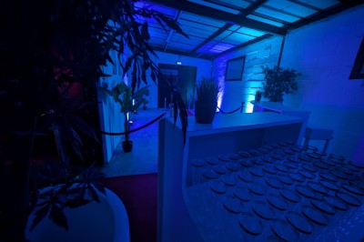 Miniature Location salle Seclin (Nord) - Luminaria #162 Décor festif avec ballons noirs, dorés, argentés et blancs, fond scintillant et deux tabourets blancs devant.