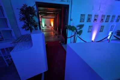 Miniature Location salle Seclin (Nord) - Luminaria #61 Décor festif avec ballons noirs, dorés, argentés et blancs, fond scintillant et deux tabourets blancs devant.