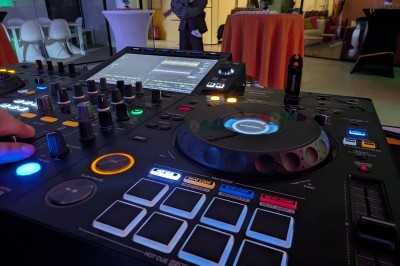 Miniature Location salle Seclin (Nord) - Luminaria #79 Décor festif avec ballons noirs, dorés, argentés et blancs, fond scintillant et deux tabourets blancs devant.