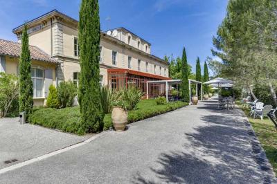 Miniature Location salle Sommières (Gard) - Domaine de l’Estelou #6 Grande table dressée en extérieur avec des chaises en bois, sous une pergola illuminée de lumières violettes, devant un…
