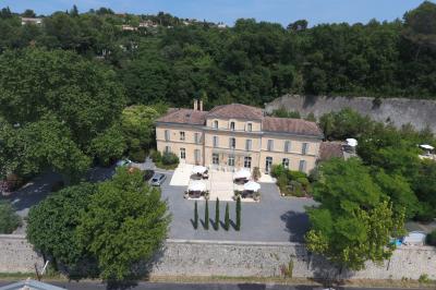 Miniature Location salle Sommières (Gard) - Domaine de l’Estelou #4 Grande table dressée en extérieur avec des chaises en bois, sous une pergola illuminée de lumières violettes, devant un…