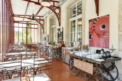 Miniature Location salle Sommières (Gard) - Domaine de l’Estelou #9 Grande table dressée en extérieur avec des chaises en bois, sous une pergola illuminée de lumières violettes, devant un…