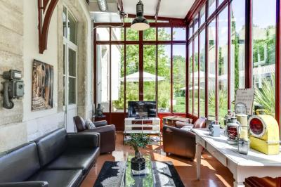 Miniature Location salle Sommières (Gard) - Domaine de l’Estelou #10 Grande table dressée en extérieur avec des chaises en bois, sous une pergola illuminée de lumières violettes, devant un…