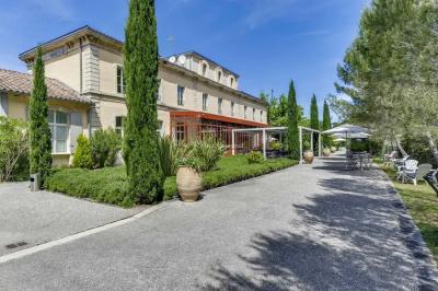 Miniature Location salle Sommières (Gard) - Domaine de l’Estelou #13 Grande table dressée en extérieur avec des chaises en bois, sous une pergola illuminée de lumières violettes, devant un…