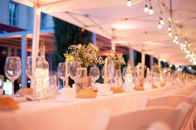 Miniature Location salle Sommières (Gard) - Domaine de l’Estelou #37 Grande table dressée en extérieur avec des chaises en bois, sous une pergola illuminée de lumières violettes, devant un…