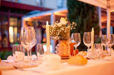 Miniature Location salle Sommières (Gard) - Domaine de l’Estelou #38 Grande table dressée en extérieur avec des chaises en bois, sous une pergola illuminée de lumières violettes, devant un…
