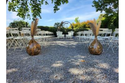 Miniature Location salle Sommières (Gard) - Domaine de l’Estelou #26 Grande table dressée en extérieur avec des chaises en bois, sous une pergola illuminée de lumières violettes, devant un…