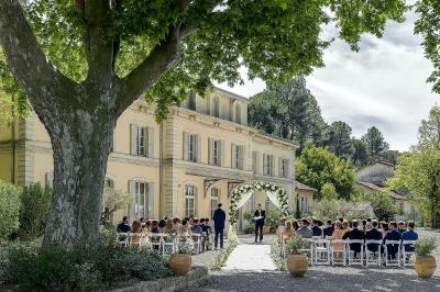 Miniature Location salle Sommières (Gard) - Domaine de l’Estelou #25 Grande table dressée en extérieur avec des chaises en bois, sous une pergola illuminée de lumières violettes, devant un…