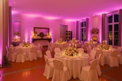 Miniature Location salle Sommières (Gard) - Domaine de l’Estelou #41 Grande table dressée en extérieur avec des chaises en bois, sous une pergola illuminée de lumières violettes, devant un…