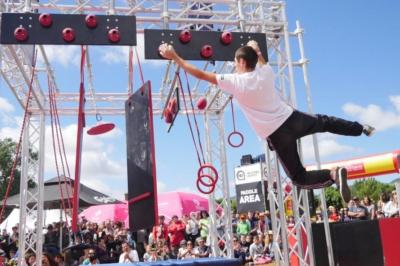 Deux acrobates exécutent une figure d'équilibre sur une caisse, devant un public dans un espace éclairé.