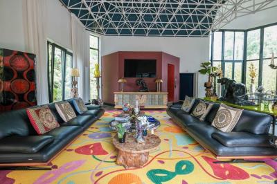 Maison contemporaine en cuivre avec grandes baies vitrées, terrasses et piscine, entourée de végétation.