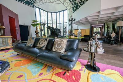 Maison contemporaine en cuivre avec grandes baies vitrées, terrasses et piscine, entourée de végétation.