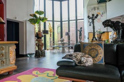 Maison contemporaine en cuivre avec grandes baies vitrées, terrasses et piscine, entourée de végétation.