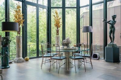 Maison contemporaine en cuivre avec grandes baies vitrées, terrasses et piscine, entourée de végétation.