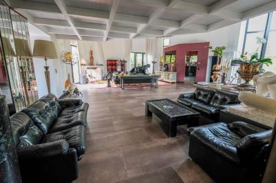 Maison contemporaine en cuivre avec grandes baies vitrées, terrasses et piscine, entourée de végétation.