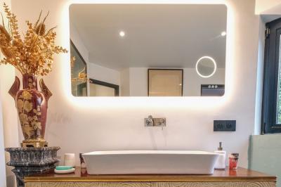 Maison contemporaine en cuivre avec grandes baies vitrées, terrasses et piscine, entourée de végétation.