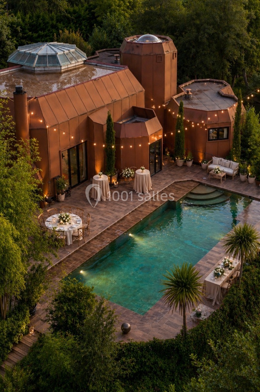 Maison moderne en briques rouges avec piscine éclairée, entourée de végétation et décorée pour un événement en soirée.