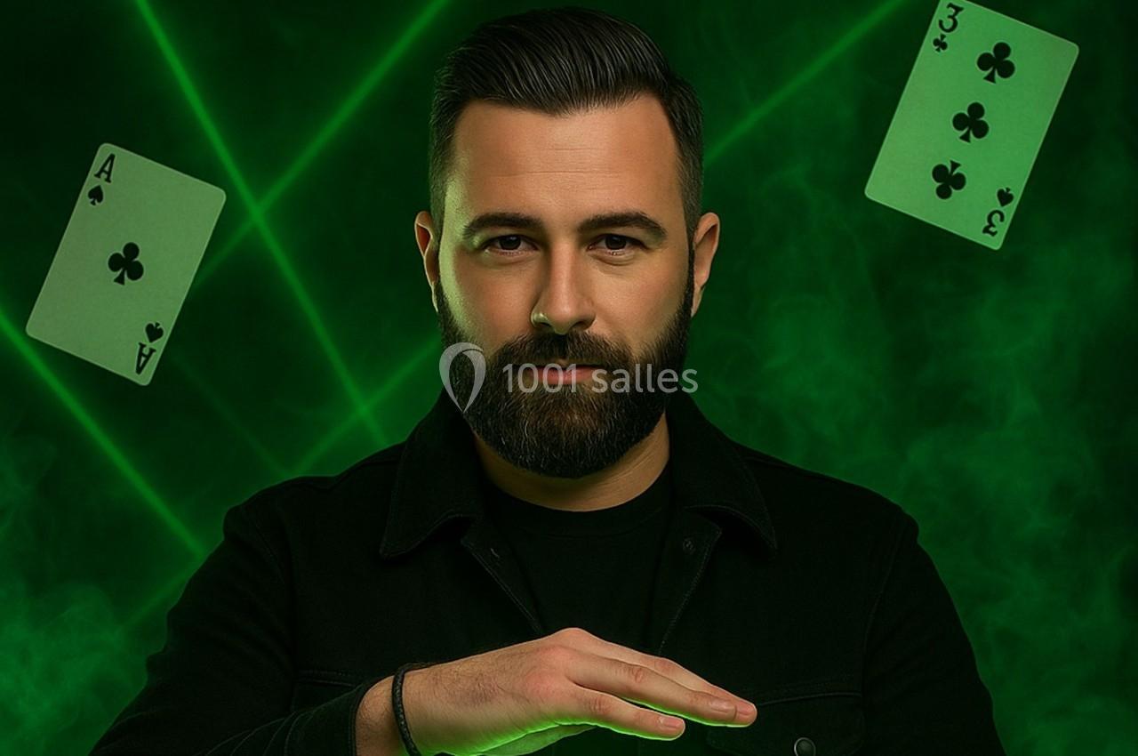 Un homme barbu pose devant un fond vert avec des cartes de trèfle flottant et des faisceaux lumineux.
