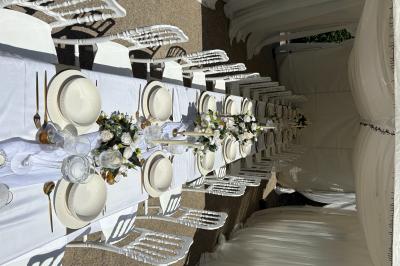 Miniature Leya Réception #2 Bougies blanches et roses dans des vases en verre décorent une table recouverte d'une nappe blanche.