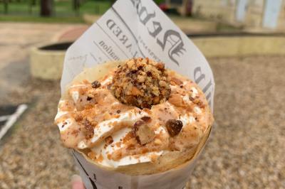 Miniature Traiteur Pessac-sur-Dordogne (Gironde) - Vm Truck #4 Crêpe garnie de crème fouettée, sauce caramel, éclats de noisettes et boule de praliné, tenue dans une main.