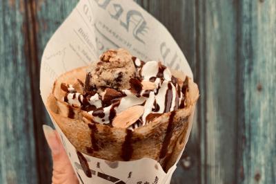 Miniature Traiteur Pessac-sur-Dordogne (Gironde) - Vm Truck #3 Crêpe garnie de crème fouettée, sauce caramel, éclats de noisettes et boule de praliné, tenue dans une main.