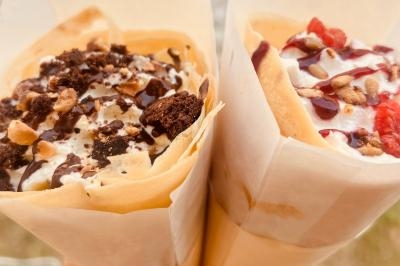 Miniature Traiteur Pessac-sur-Dordogne (Gironde) - Vm Truck #12 Crêpe garnie de crème fouettée, sauce caramel, éclats de noisettes et boule de praliné, tenue dans une main.