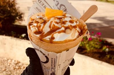 Miniature Traiteur Pessac-sur-Dordogne (Gironde) - Vm Truck #17 Crêpe garnie de crème fouettée, sauce caramel, éclats de noisettes et boule de praliné, tenue dans une main.