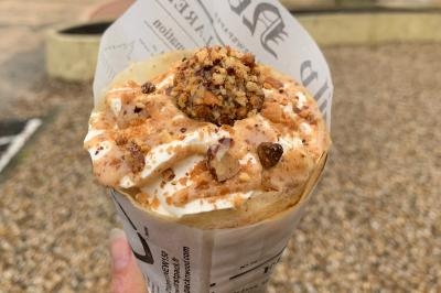 Miniature Traiteur Pessac-sur-Dordogne (Gironde) - Vm Truck #18 Crêpe garnie de crème fouettée, sauce caramel, éclats de noisettes et boule de praliné, tenue dans une main.