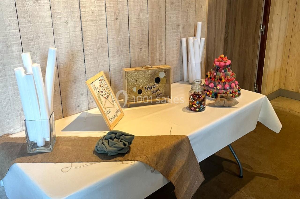 Table décorée avec des éléments de fête, comprenant un arbre de bonbons, un bocal de friandises et des cadres décoratifs.
