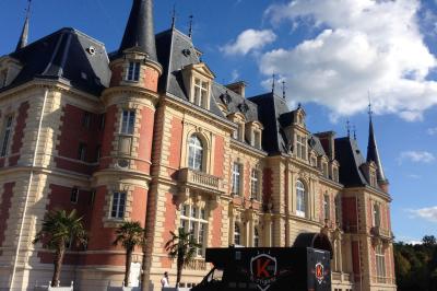 Un food truck servant des crêpes dans un parc avec des tables et des clients assis ou en file d'attente.
