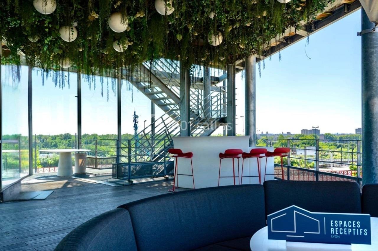 Location salle Caluire-et-Cuire (Rhône) - Le Belvédère #7 Terrasse couverte avec vue dégagée, mobilier moderne, plafond végétalisé et escalier métallique en arrière-plan.