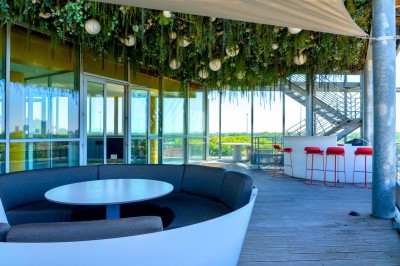 Miniature Location salle Caluire-et-Cuire (Rhône) - Le Belvédère #9 Terrasse en bois avec mobilier moderne, vue sur la ville, végétation suspendue et voile d'ombrage.