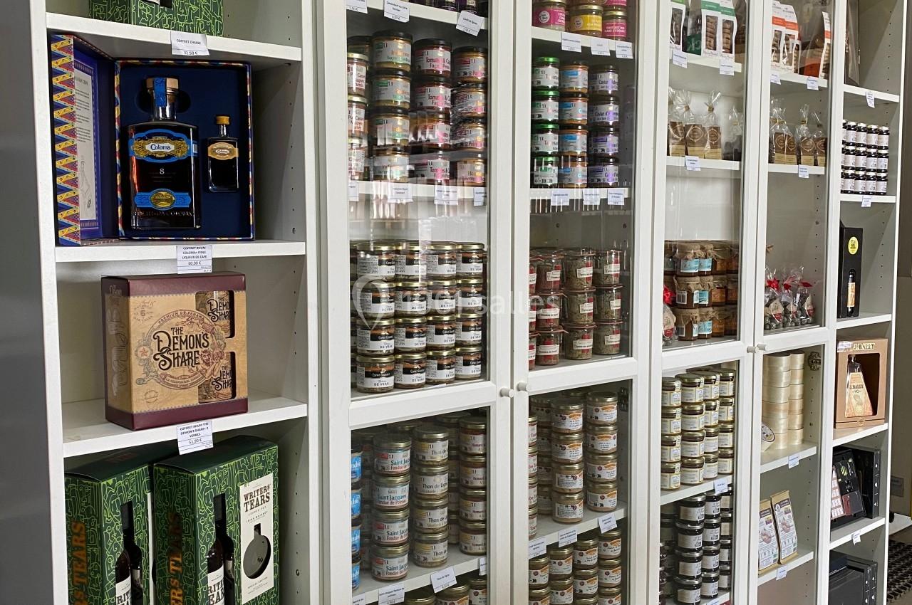 Étagères vitrées contenant des produits alimentaires variés, tels que conserves, huiles et coffrets cadeaux.