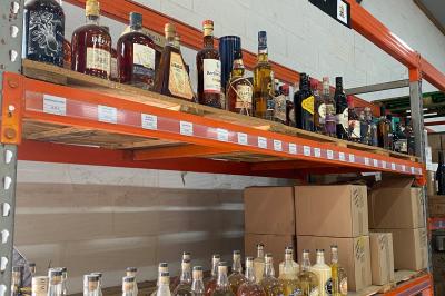 Alignement de remorques frigorifiques blanches stationnées sur un parking, entourées d'arbres et de ciel dégagé.