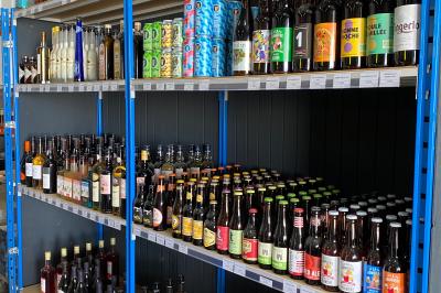 Alignement de remorques frigorifiques blanches stationnées sur un parking, entourées d'arbres et de ciel dégagé.