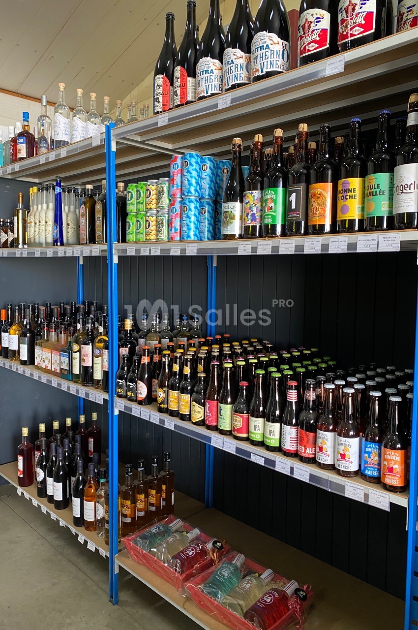 Étagères remplies de bouteilles d'alcool variées, incluant bières, vins et spiritueux, dans un magasin.