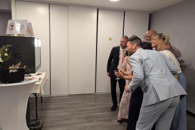 Miniature Mariage Domaine de St Vigor Des personnes dansent et discutent dans une salle éclairée par des lumières colorées lors d'un événement festif.