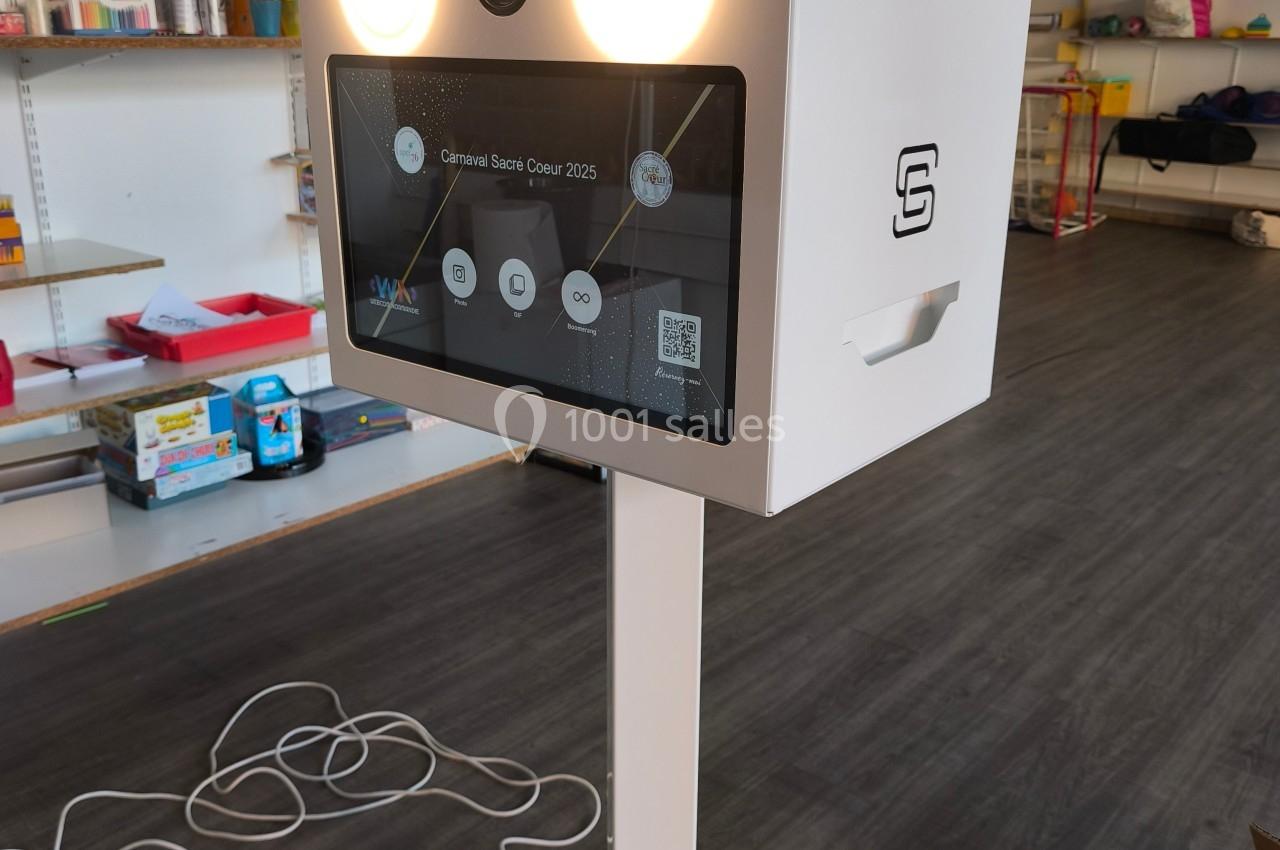 Borne photo interactive sur pied avec écran tactile et éclairage intégré, installée dans un espace intérieur.
