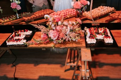 Table décorée avec des fleurs colorées, des fruits et des couverts disposés pour un repas festif.