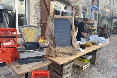 Chambre spacieuse sous combles avec poutres apparentes, lit double, coin salon coloré et grande baie vitrée.