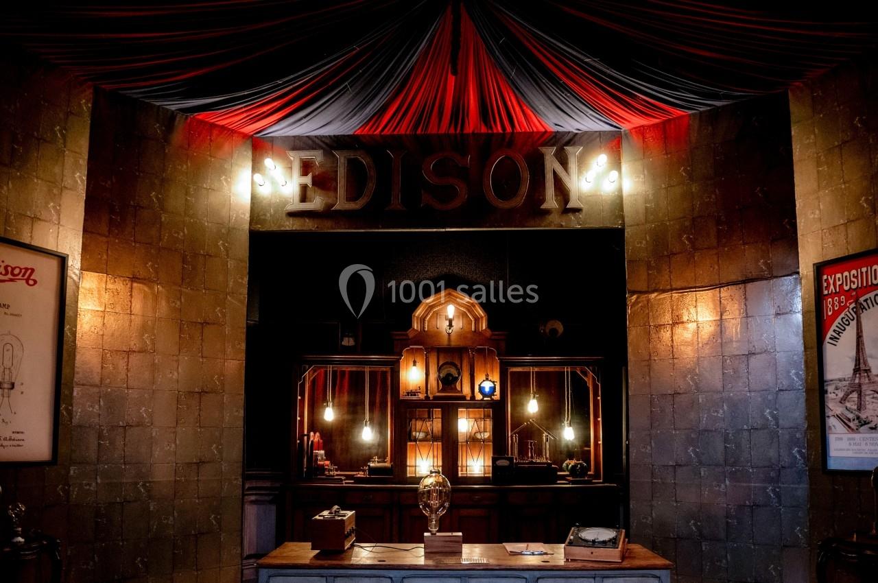 Entrée d'un espace rétro avec une enseigne ’Edison’, des lumières suspendues et un comptoir en bois.