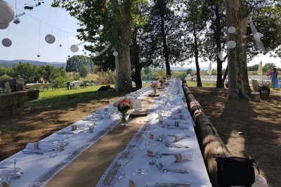 Chambre avec lit double bleu, tête de lit en rotin, décoration sobre et tableau représentant un ponton sur la mer.
