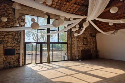 Chambre avec lit double bleu, tête de lit en rotin, décoration sobre et tableau représentant un ponton sur la mer.