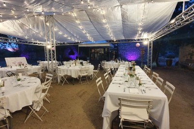 Chambre avec lit double bleu, tête de lit en rotin, décoration sobre et tableau représentant un ponton sur la mer.