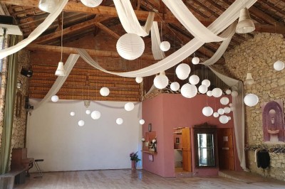 Chambre avec lit double bleu, tête de lit en rotin, décoration sobre et tableau représentant un ponton sur la mer.
